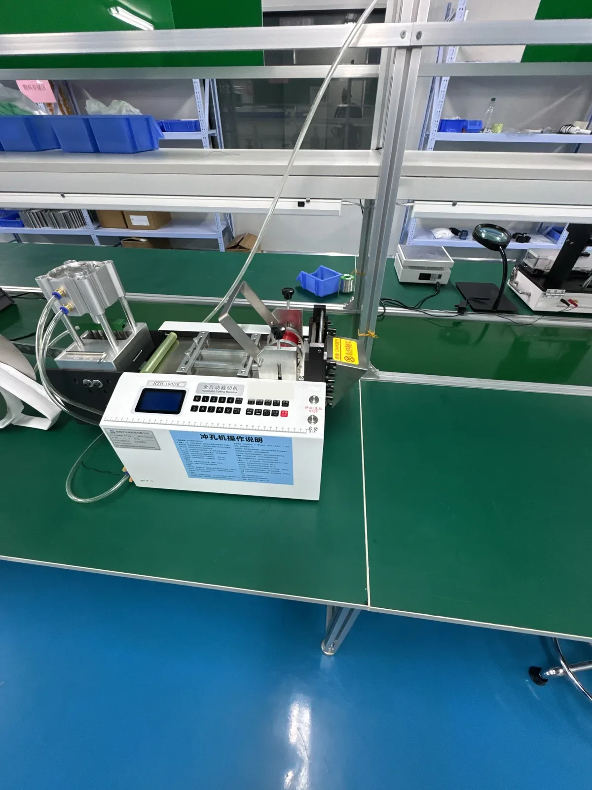 Bench-mounted punching machine set up on a production-line work surface for forming stainless-steel components