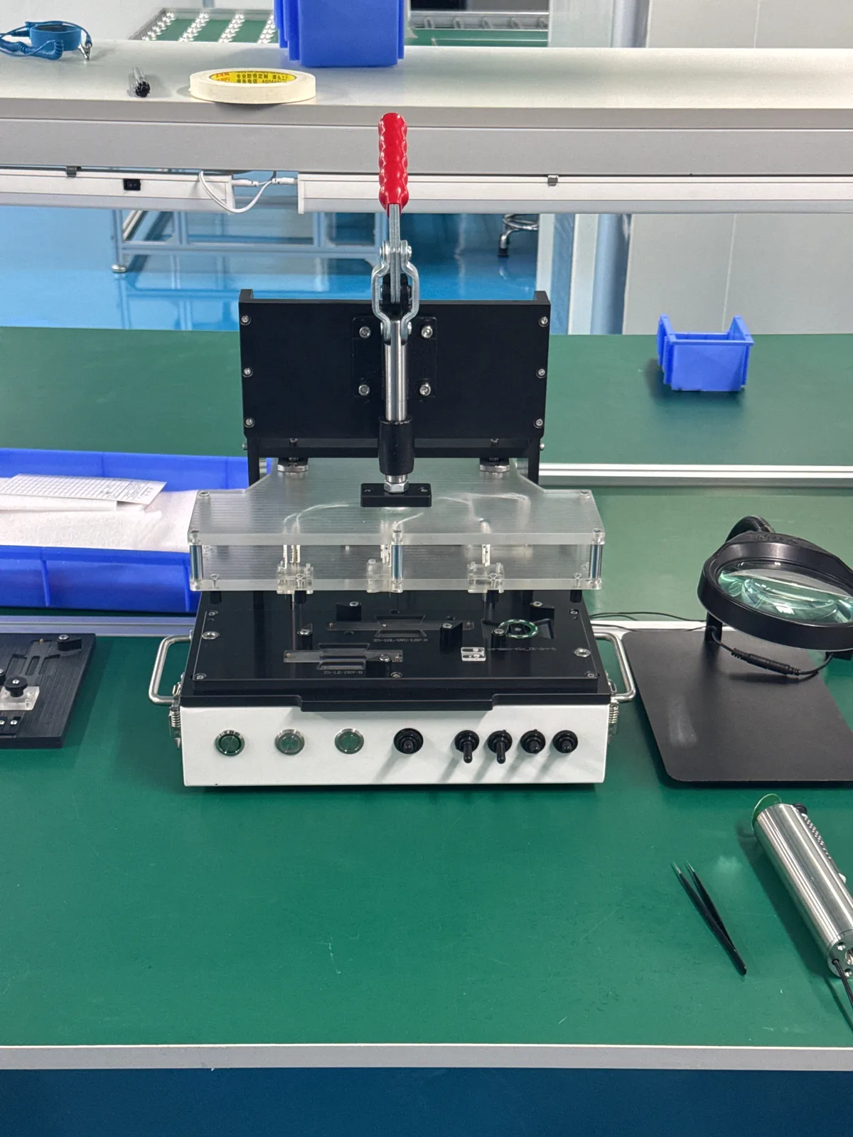 Purpose-built test fixture with an acrylic guard and a bank of indicator lamps, used to check sterilizer sub-assemblies before final assembly